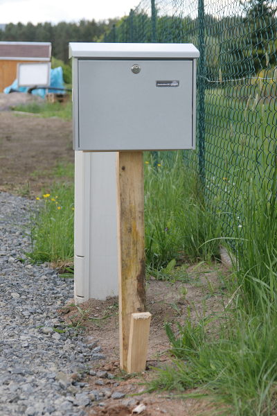 Der Briefkasten auf einem Holzpflock