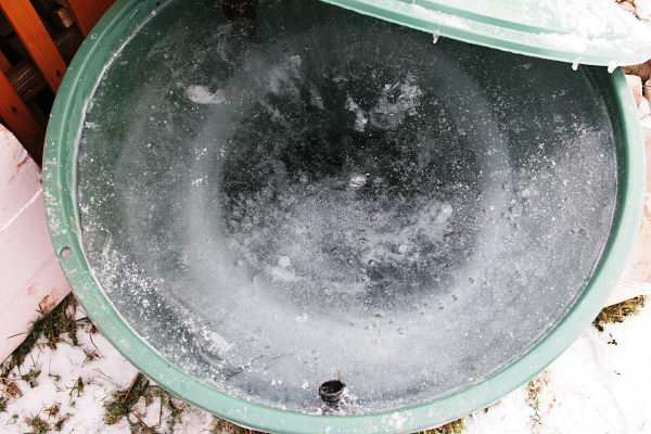 In the rain barrel the water is frozen to about 2/3 of the total.