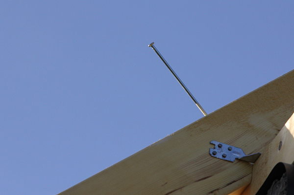 A long straight nail in a wooden beam