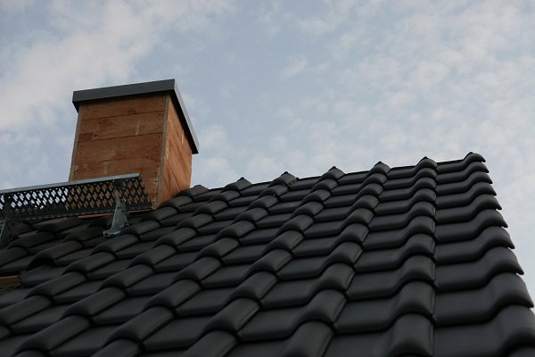 Ein Foto des Schornsteins mit den bereits gelegten Dachziegeln.