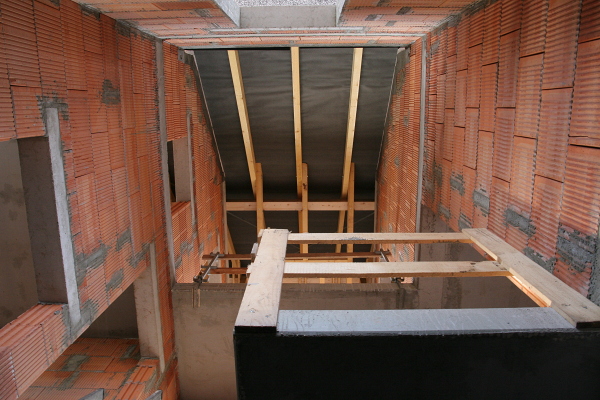 View up the stair case with the roof skeleton visible.