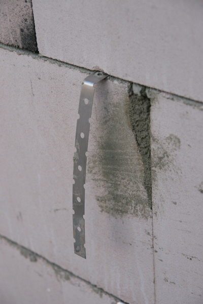 Metallfahne, die zwischen zwei Steinen aus der Wand schaut
